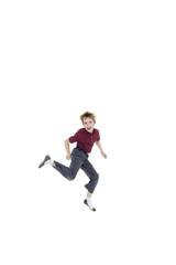 Fototapeta na wymiar Portrait of cheerful pre-teen boy jumping over white background