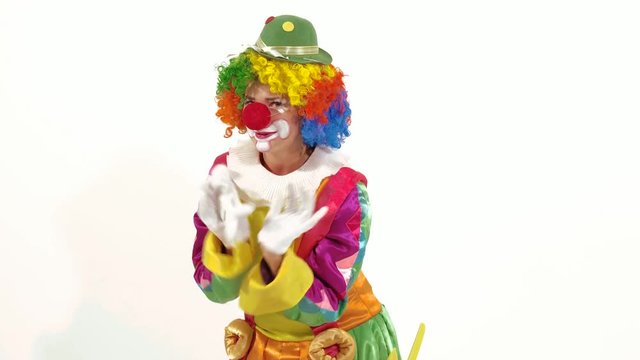Funny and pretty clown making faces in front of the camera