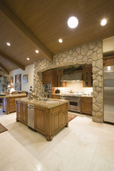 Exposed stone kitchen surround with spotlights on wooden ceiling