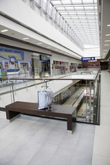 Paper bag on wooden bench in shopping centre