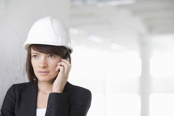 Closeup of female architect using cell phone in empty warehouse