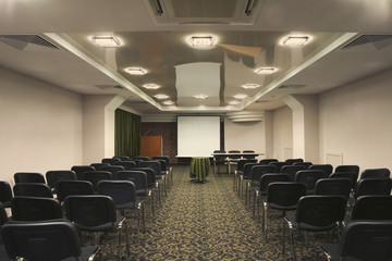 An empty presentation room with chairs arranged in a row