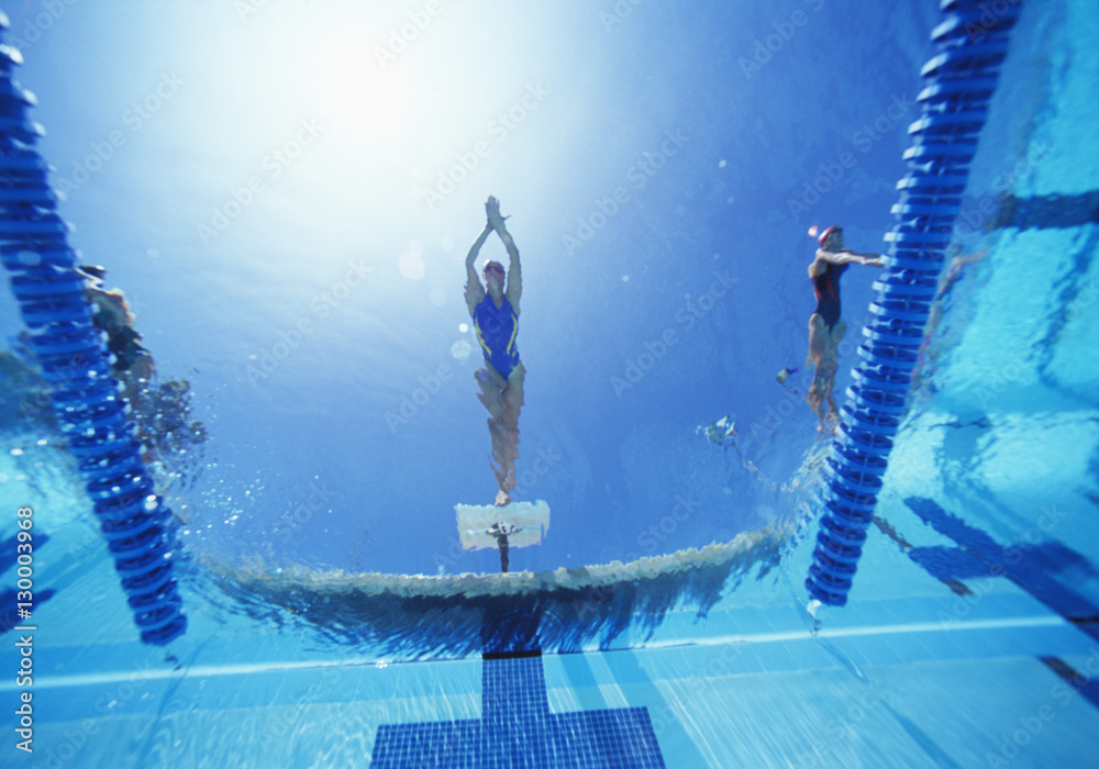 Wall mural view of female swimmer diving in swimming pool