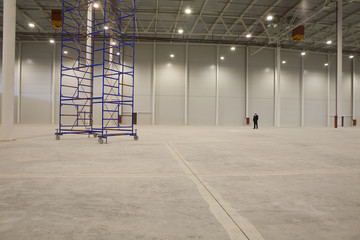 Movable stacking frame in empty warehouse with businessman in background