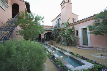 Water feature and metal steps in courtyard garden at home
