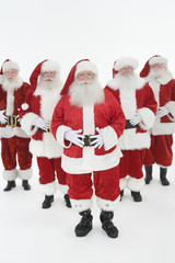 Group portrait of men dressed in Santa Claus outfits isolated over white background