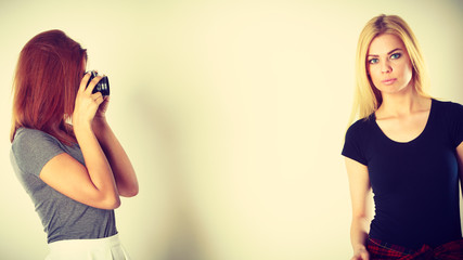 girl photographing blonde woman