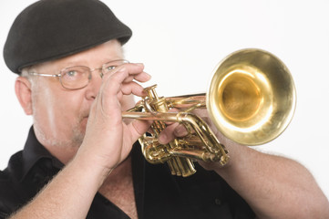 Man playing trumpet isolated over white background © MDBPIXS