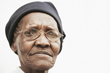 Closeup portrait of elderly woman wearing glasses over white background