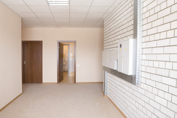 Fototapeta na wymiar Tiled wall with fusebox in wide hallway