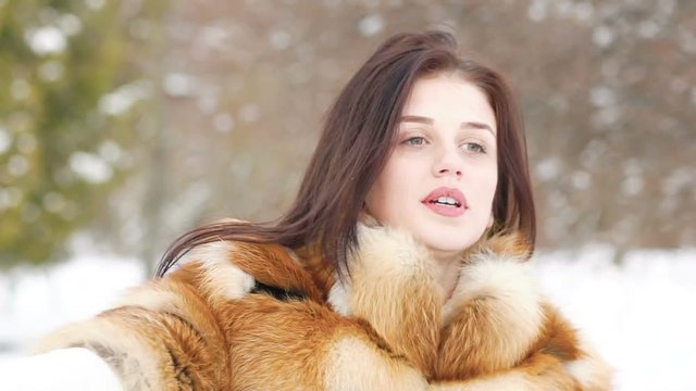 Pretty girl covered in shawl in the winter forest