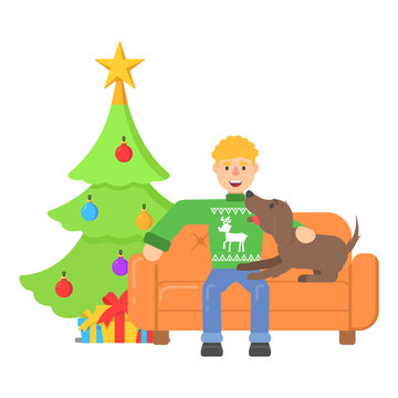 Christmas character young man in red pullower with deer sitting on couch with dog