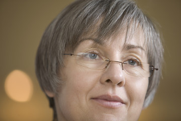 Closeup of thoughtful middle age woman wearing glasses while looking away