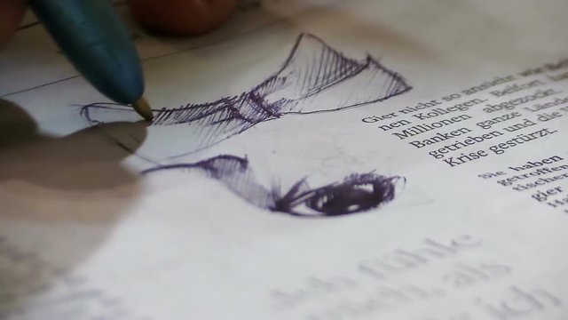 drowing on the page of a book with a pen