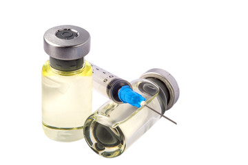 3 ml transparent medical syringe without needle cap lying on ampule with liquid drug. Shadow, white background. One ampule lying, one bottle full with slighly yellow drug standing.
