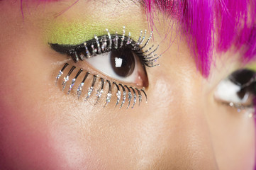 Extreme close-up of young funky woman's face with false eyelashes
