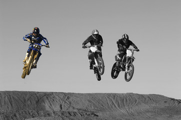 Fototapeta na wymiar Young motocross racers riding on dirt track