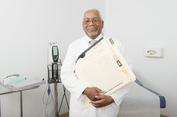 Portrait of an African American male doctor holding files and documents at clinic