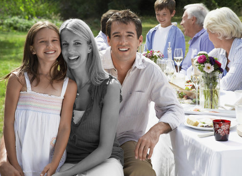 Multi-generation Family Having Meal At Dining Table In Backyard