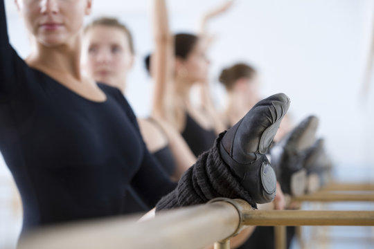 Row Of Ballet Dancers Practicing At The Barre In Rehearsal Room