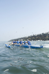 Rear view of multiethnic outrigger canoeing team heading to race stage