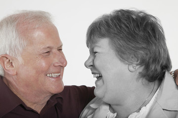 Senior couple looking at each other against white background