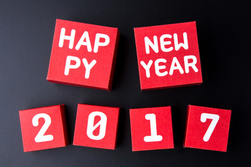 Happy new year 2017 number on red paper box cubes on black backg
