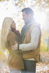 Fototapeta premium Side view of couple hugging in park