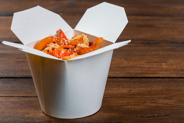 Noodles in a white box on wooden background