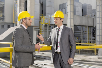 Young male engineers discussing at construction site