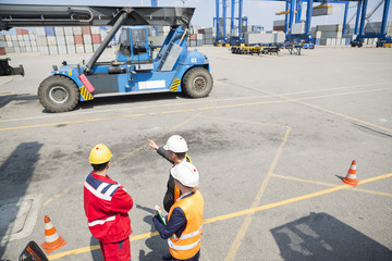 Naklejka premium High angle view of workers discussing in shipping yard