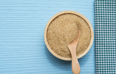 sugar in wood bowl on a blue table