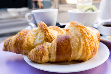 Breakfast with coffee and croissants on table