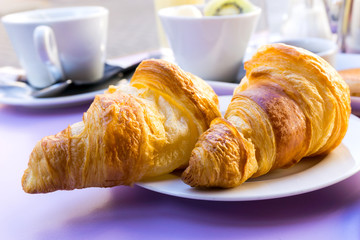 Breakfast with coffee and croissants on table