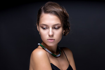 Portrait of a teenage girl on a dark gray background.