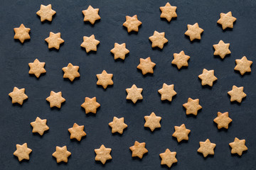 Pattern of star shaped cookies on dark background. Christmas, New Year, holidays concept