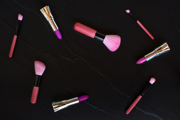 top view pink color makeup brushes and lipsticks