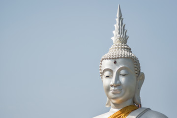 Fototapeta premium The White buddha status on blue sky background , Thailand