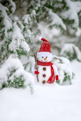 christmas toy of the snowman in snow covered forest