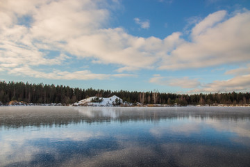 Fototapeta na wymiar Rural landscape. Beautiful winter sky over snowy and icy lake
