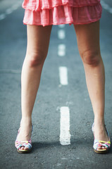 young beautiful girl in short dress standing on the road