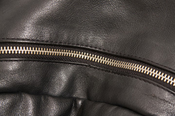 A zipper on the black backpack.