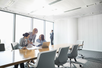 Businesswomen looking at documents in conference meeting