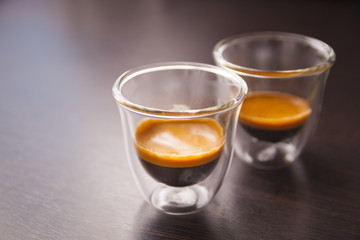 Cup of coffee in thermoglass, brown background