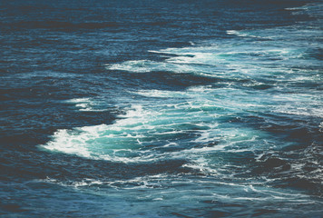 Waves behind boat while cruise through ocean in bright sun light