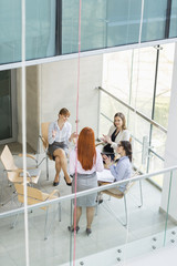 High angle view of businesswoman giving presentation to colleagues in office