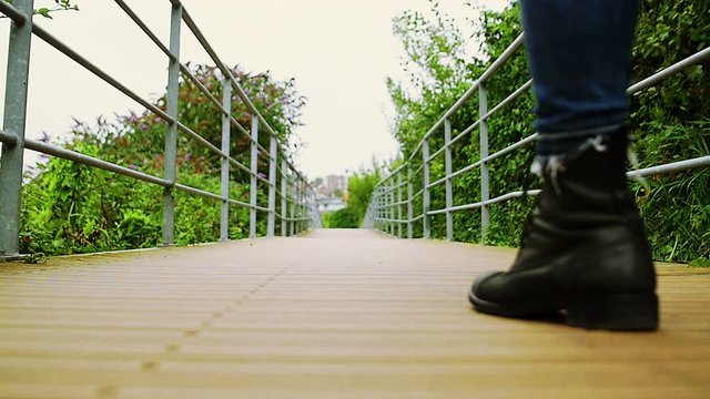 Feet Of Woman Walking In Slow Motion Over A Bridge