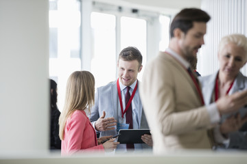 Happy businessman discussing with colleague in convention center
