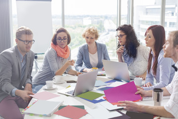 Creative business colleagues analyzing photographs at conference table in office