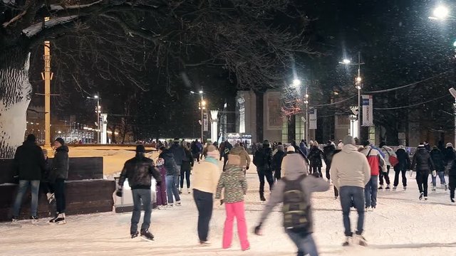 People skate on the rink outdoors